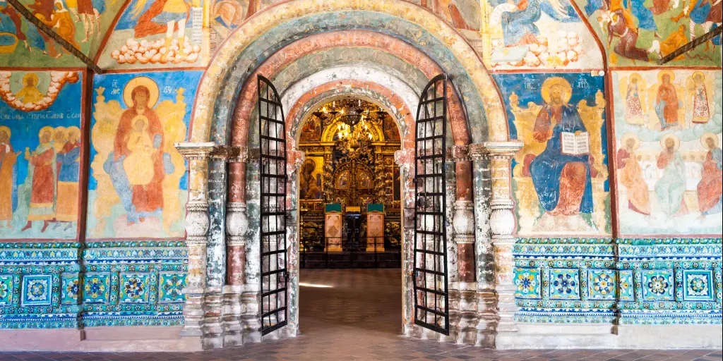 Arched internal doorway surrounded by colourful wall painting with icons in the Church of Elijah the Prophet in Yaroslavl, Russia