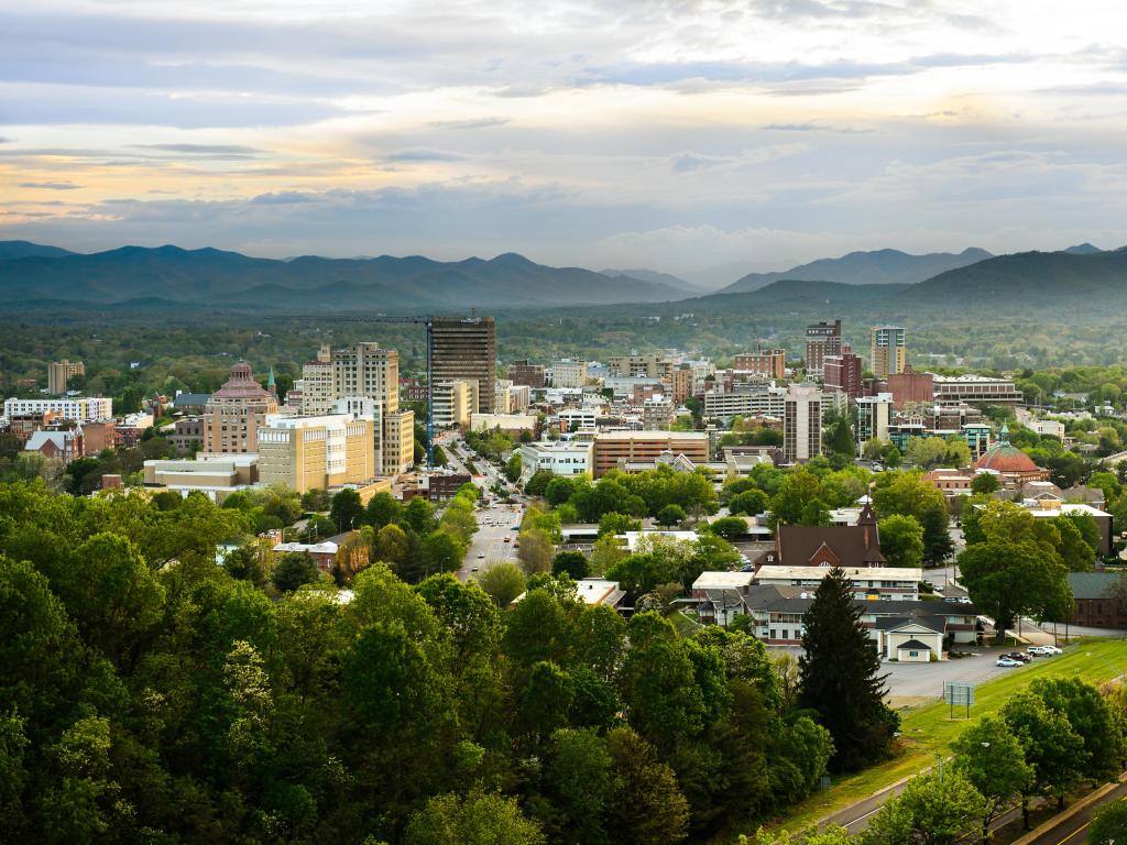 Asheville, North Carolina, USA with the skyline of downtown taken at sunset with mountains in the background.