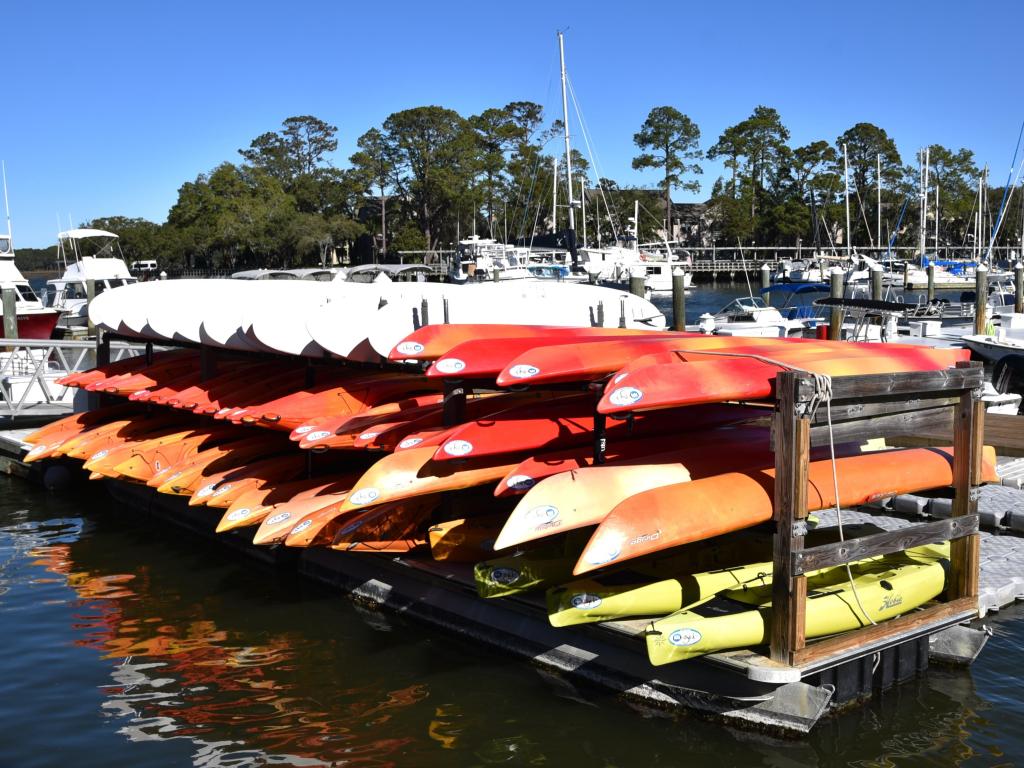 Colorful kayaks stacked and ready for rent in the marina at Hilton Head Island on a sunny day