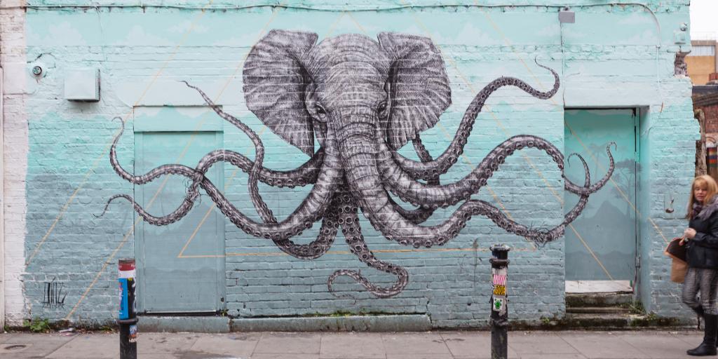 Some street art of an elephant octopus on a blue wall in Shoreditch, London 