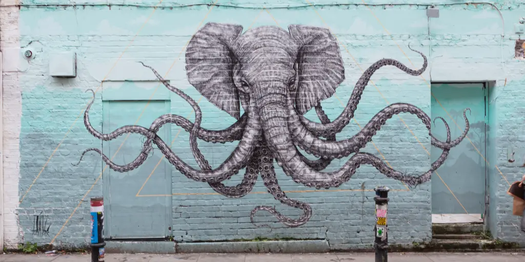 Some street art of an elephant octopus on a blue wall in Shoreditch, London 