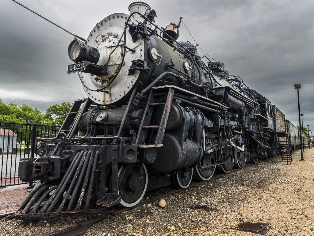 An old locomotive, immobile on the tracks, in Temple Railroad & Heritage Museum. Photo taken on a cloudy day.