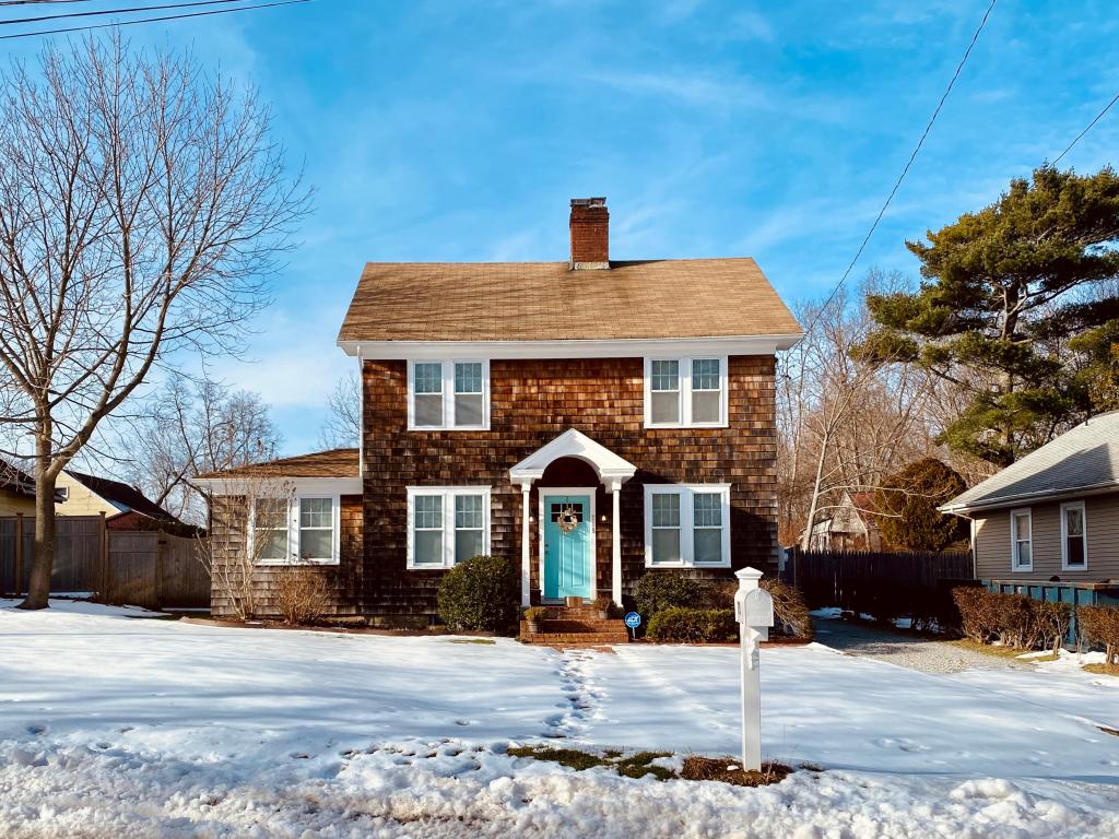 A charming brick home on a snow-covered street in Long Island