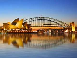 The view of Sydney Opera House and bridge viewed from Circular Quay as the sun sets