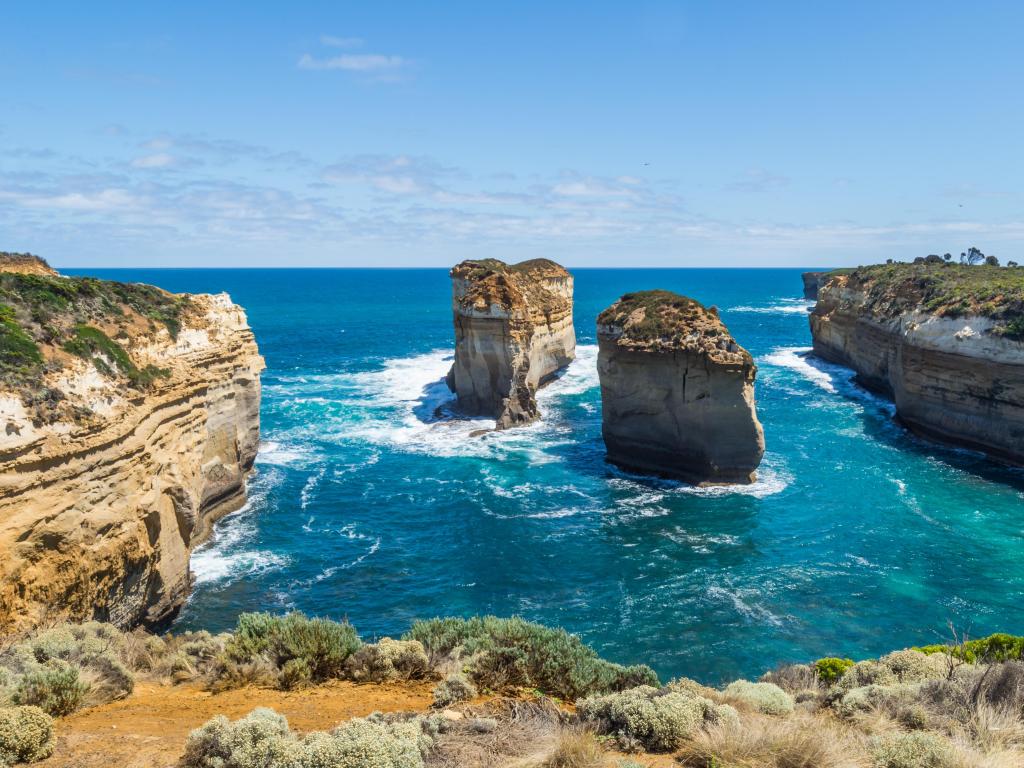 Port Campbell National Park, Great Ocean Road in Victoria, Australia with limestone stacks near Loch Ard Gorge on a clear day with the sea in the foreground.
