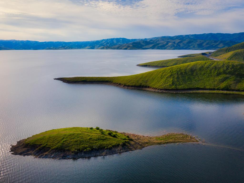 The man-made San Luis Reservoir, California, with gently undulating grassy islands rising from the still waters