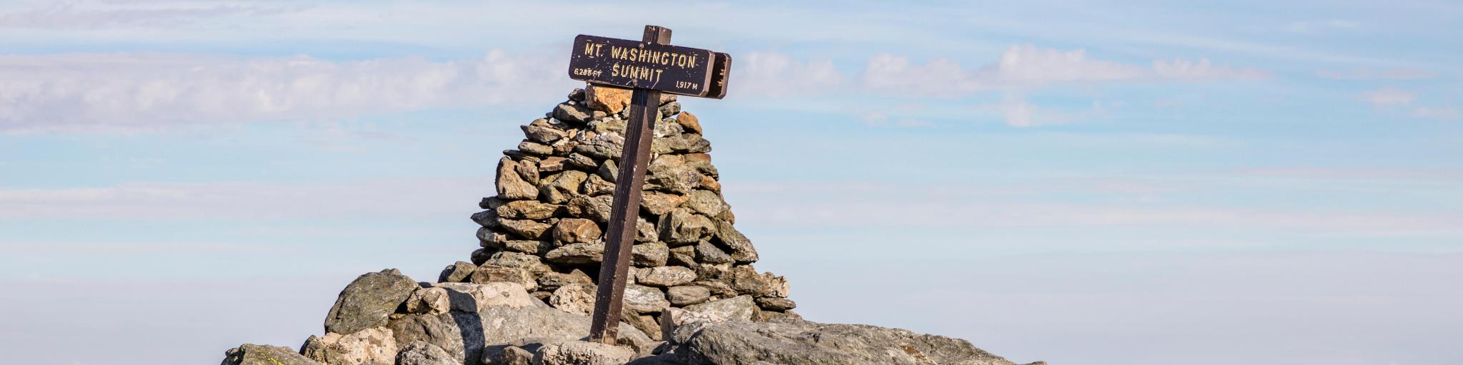 Wooden sign at the Mount Washington Summit, NH, on a clear day