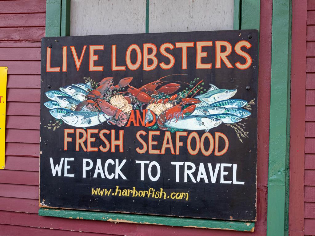 Shop chalkboard sign selling live lobsters in Portland, Maine