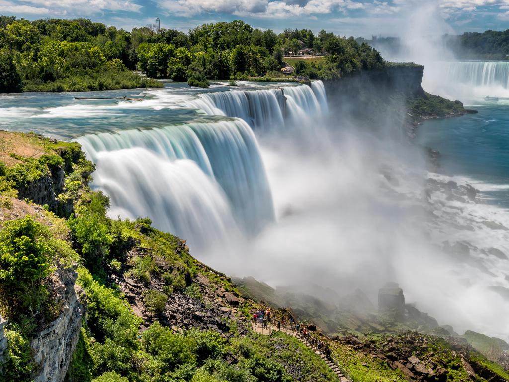 Niagara Falls, New York, USA with a view of the American Falls and Bridal Veil Falls on a sunny day.