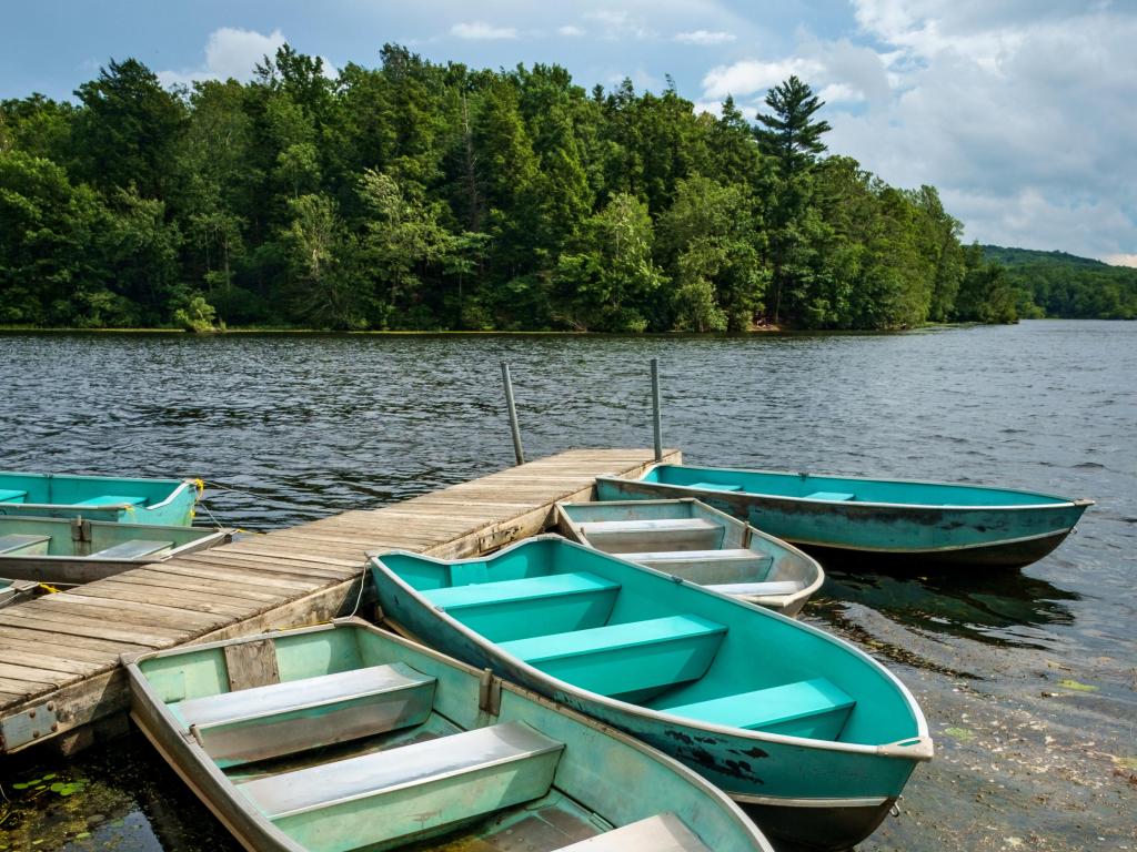 Turquoise and white rowing boats tied to the dock on lake at Wawayanda State Park