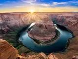 Grand Canyon National Park, USA at sunset showing the Horseshoe bend with the Colorado River around the rock formation and canyons in the distance.
