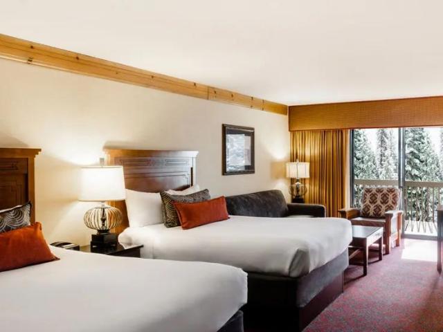 Spacious bedroom, with two double beds and alpine style decor, at Tenaya Lodge at Yosemite
