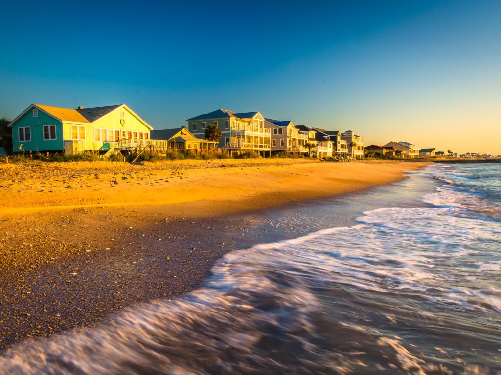 Waves in the Atlantic Ocean and morning light on beachfront homes at Edisto Beach, South Carolina.