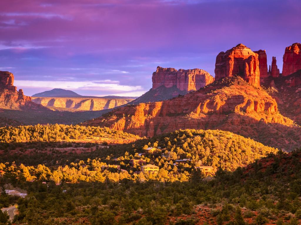 Vast red rock rising up from valley in glowing evening light