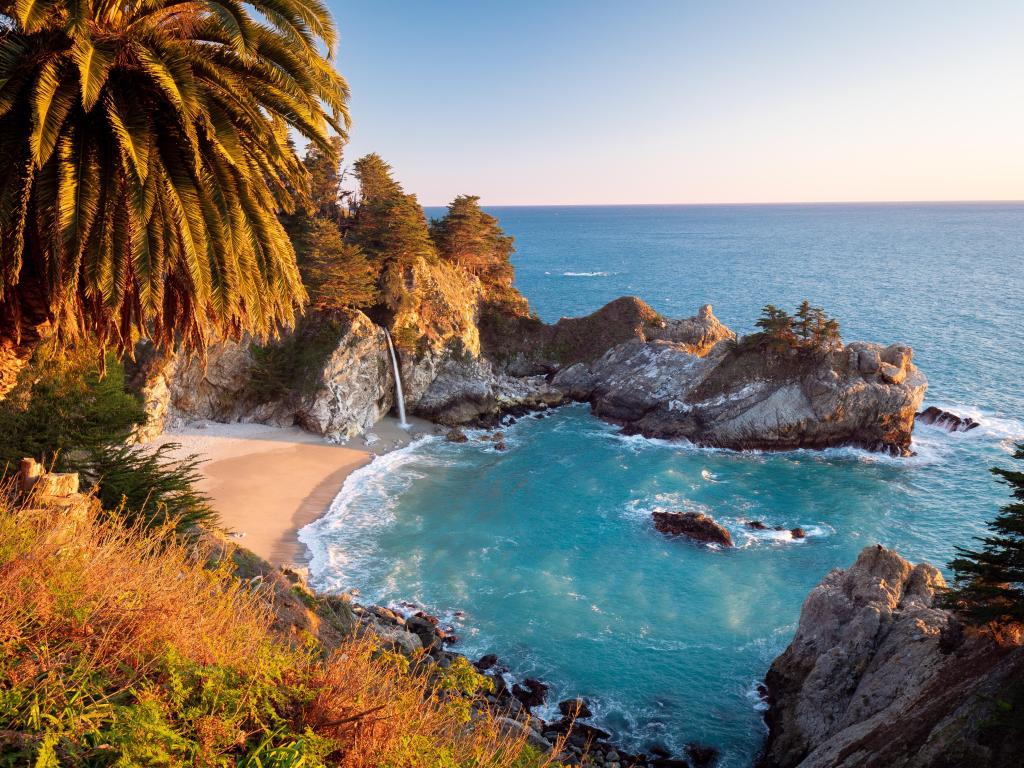 Mcway falls and cove bathed in sunset light during golden hour in Big Sur, California