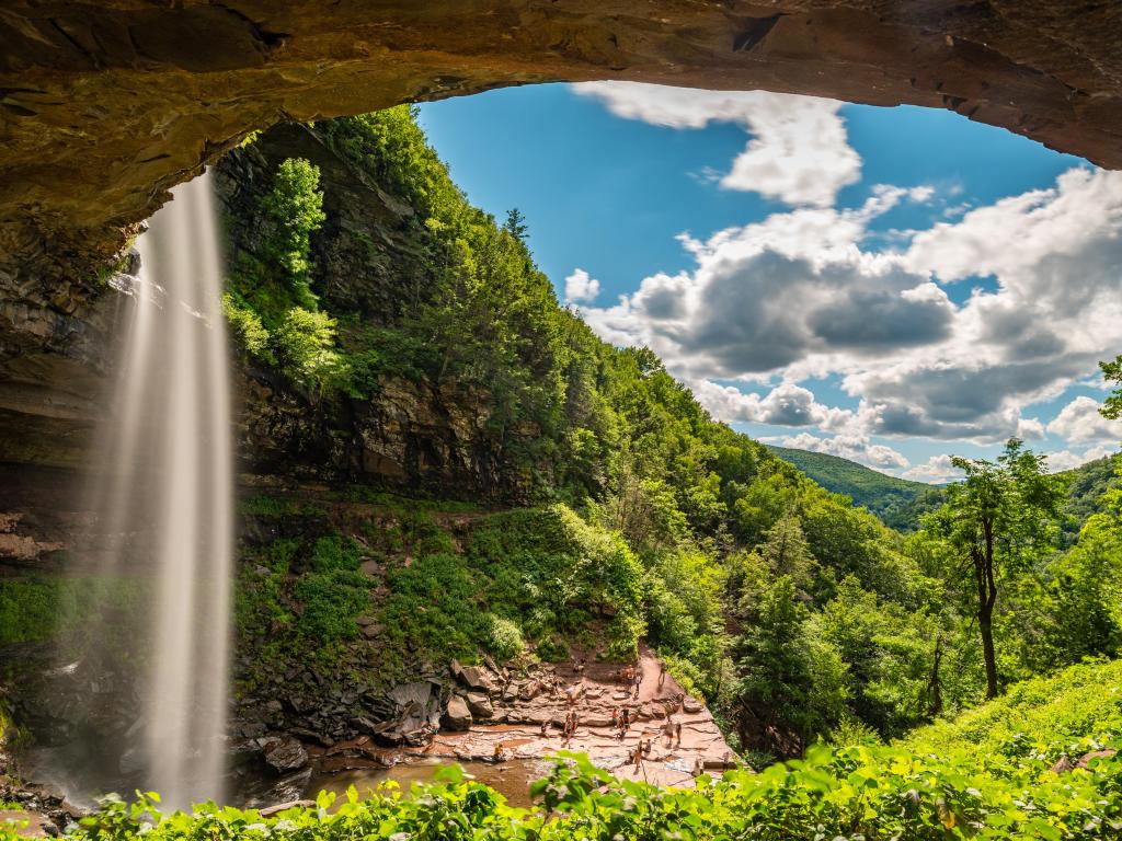 Kaaterskill Waterfall, Catskill Mountains, upstate New York, USA taken on a sunny day through a cove and overlooking a canyon full of green trees. 