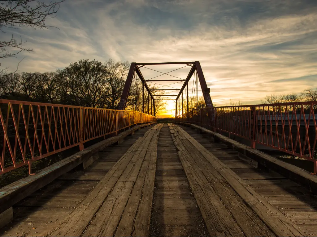 The Old Alton Bridge, also known as the Goatman Bridge, in Denton, Texas at sunset.