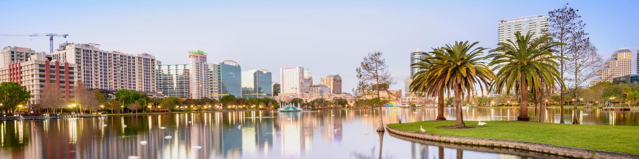 Orlando. Photo taken in the Lake Eola Park with the silhouette of the city reflecting on the lake at sunset. 