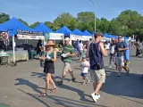 People walking past food stalls at Queens Night Market, New York