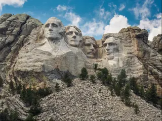 Mount Rushmore National Monument in South Dakota with a blue sky and clouds.