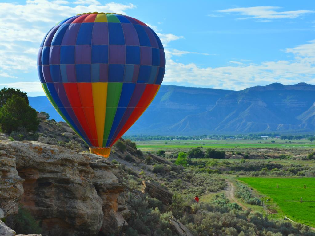 Colorful hot air balloon overlooking canyons and cliffs