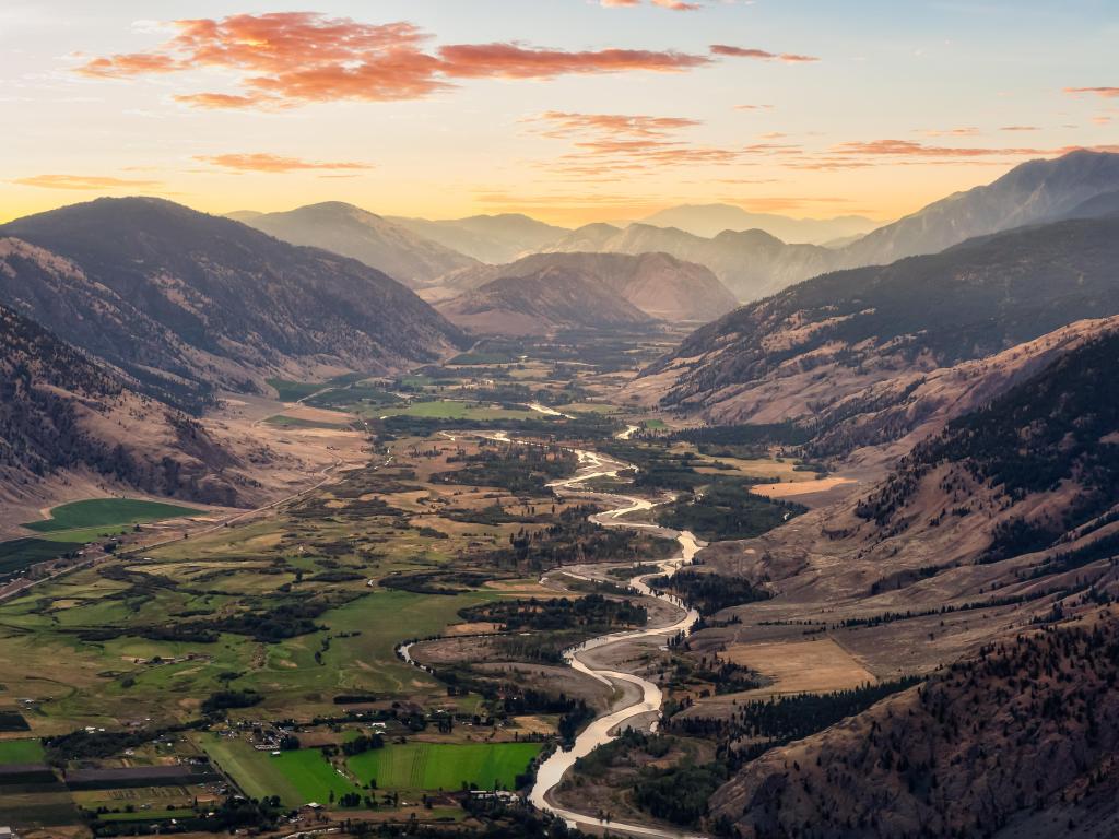 Keremeos, British Columbia, Canada with an aerial view of the valley surrounded by Canadian mountain landscapes and farm fields and taken at sunrise.