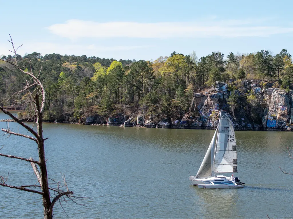 Sailboat on Lake Martin, Alabama, with rugged rocks and trees in the background