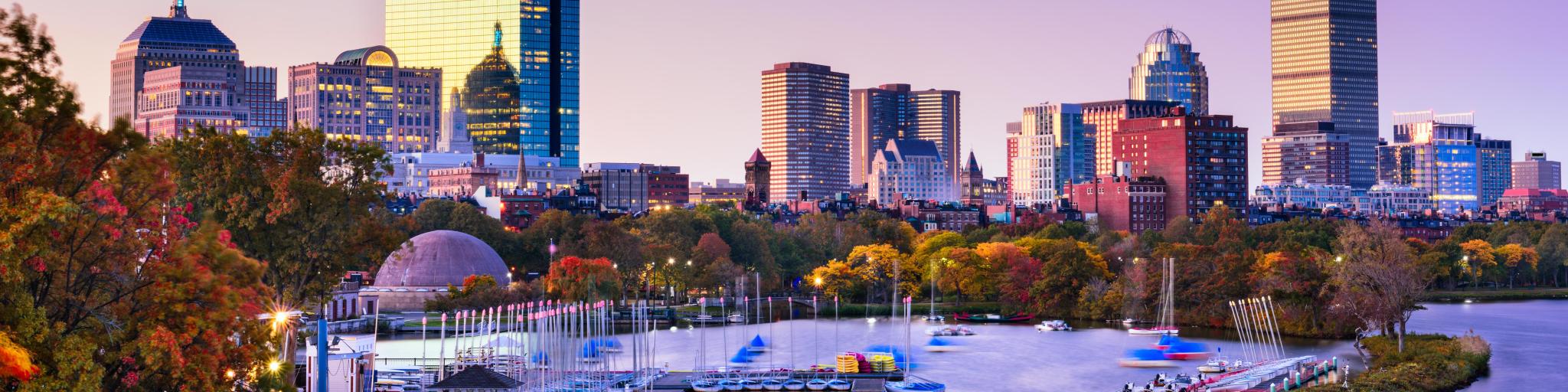 Boston, Massachusetts, USA skyline with water in the foreground at dusk.