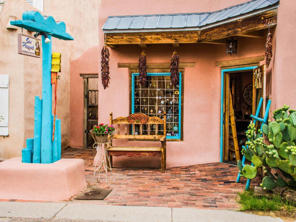 Strings of chilli peppers hang from an old house in Old Town Albuquerque, New Mexico, with turquoise shutters on the building's windows
