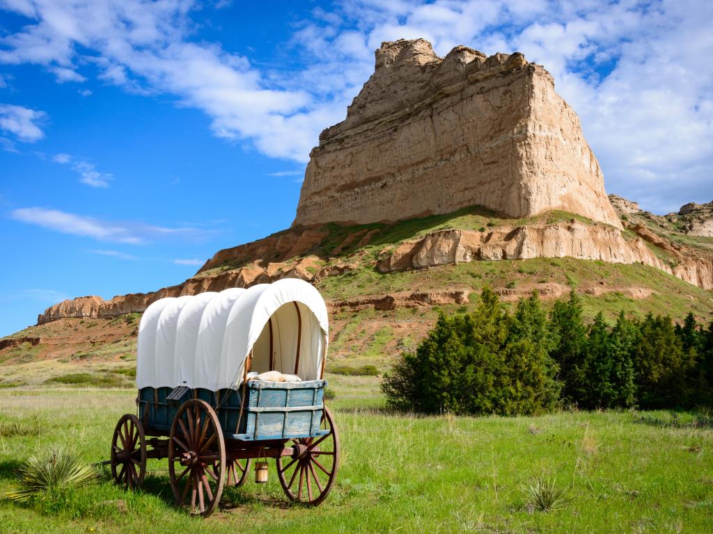 View of wagon in the forefront and Scotts Bluff National Monument in the background