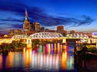 Nashville, Tennessee, USA with the skyline of downtown Nashville at night.