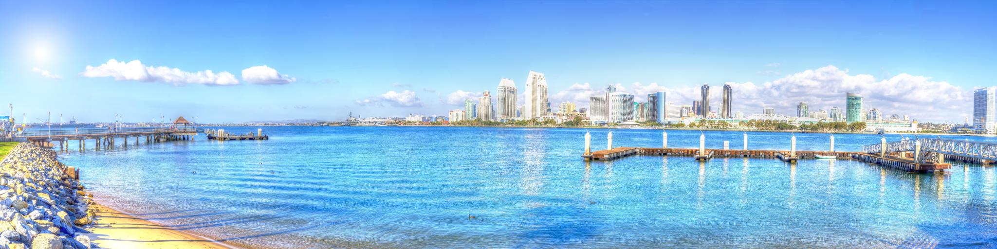 A panoramic view of the skyline of San Diego   with a thick white sheet of stretched out cotton-like clouds in a blue sky reflecting the sea in a sunny morning