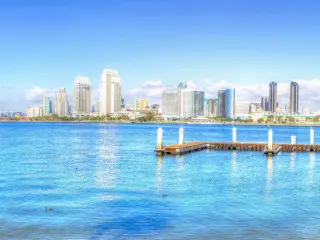 A panoramic view of the skyline of San Diego   with a thick white sheet of stretched out cotton-like clouds in a blue sky reflecting the sea in a sunny morning