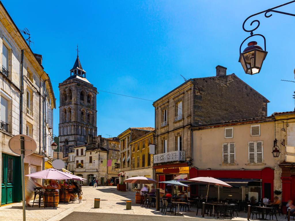 Central street of French town of Cognac overlooking bell tower of Saint Leger Church