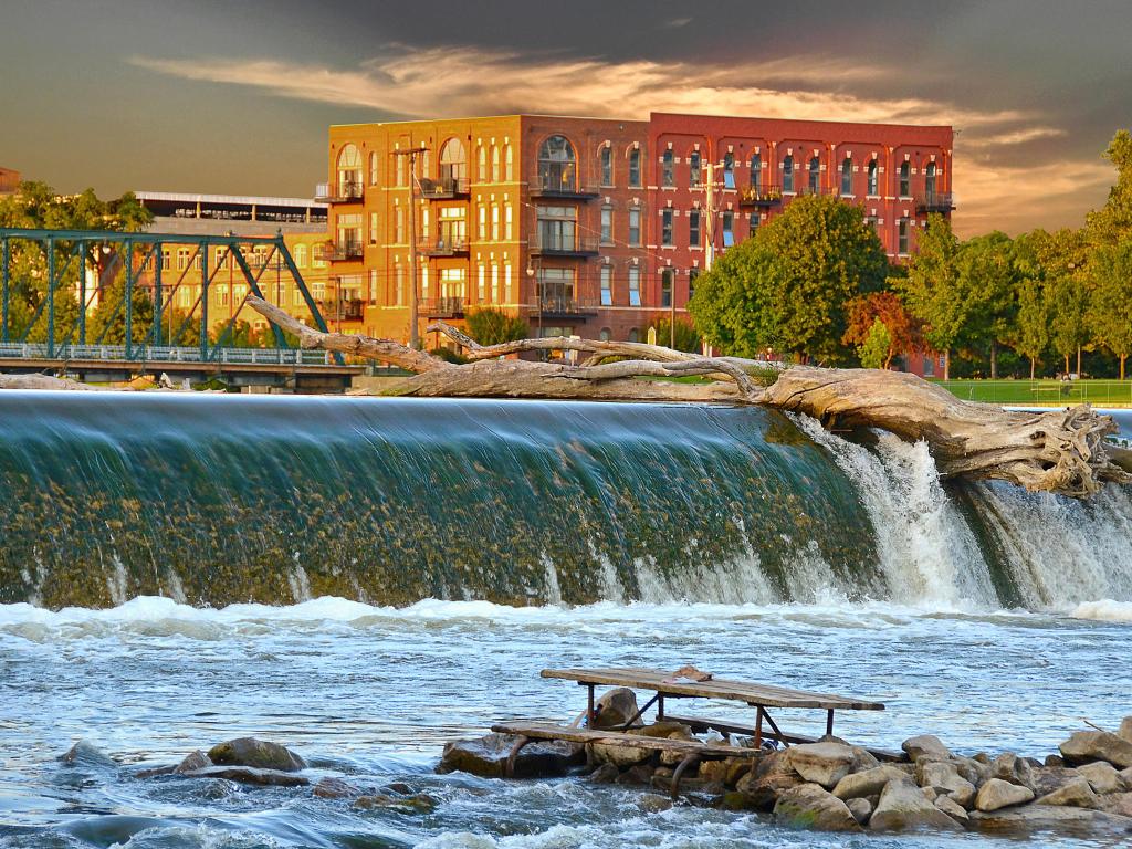 Grand Rapids, Michigan, USA with a driftwood log on top of dam on the Grand River at early evening. 