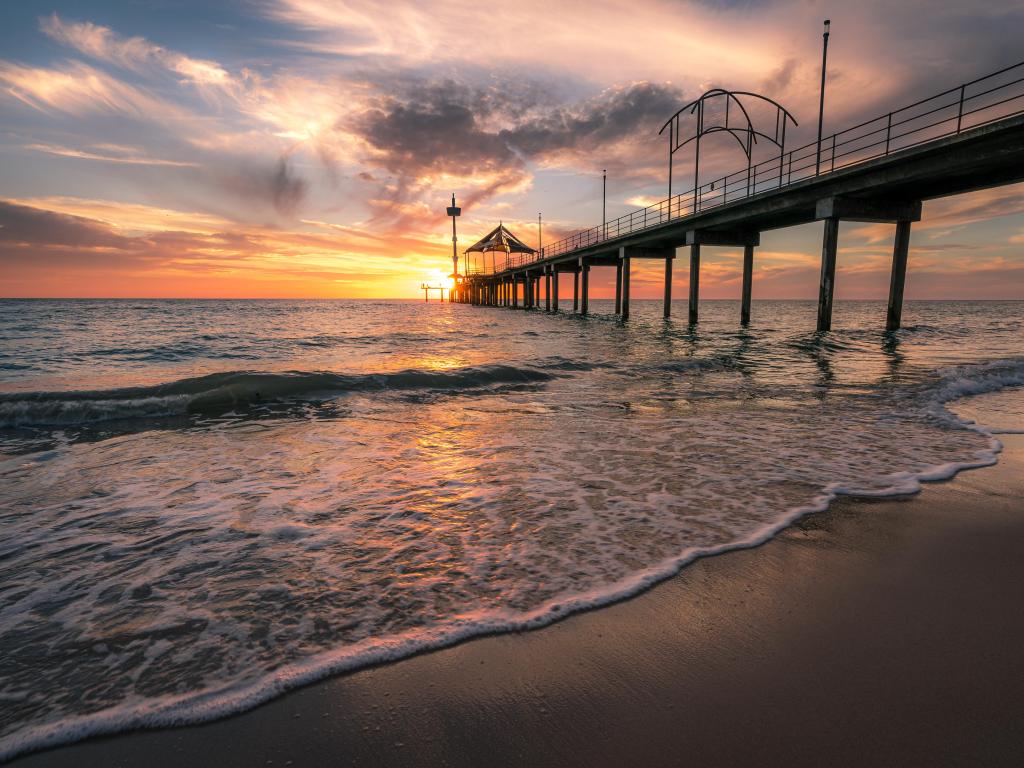 Adelaide, South Australia taken at sunset at Brighton Jetty with a calm sea and sand below.