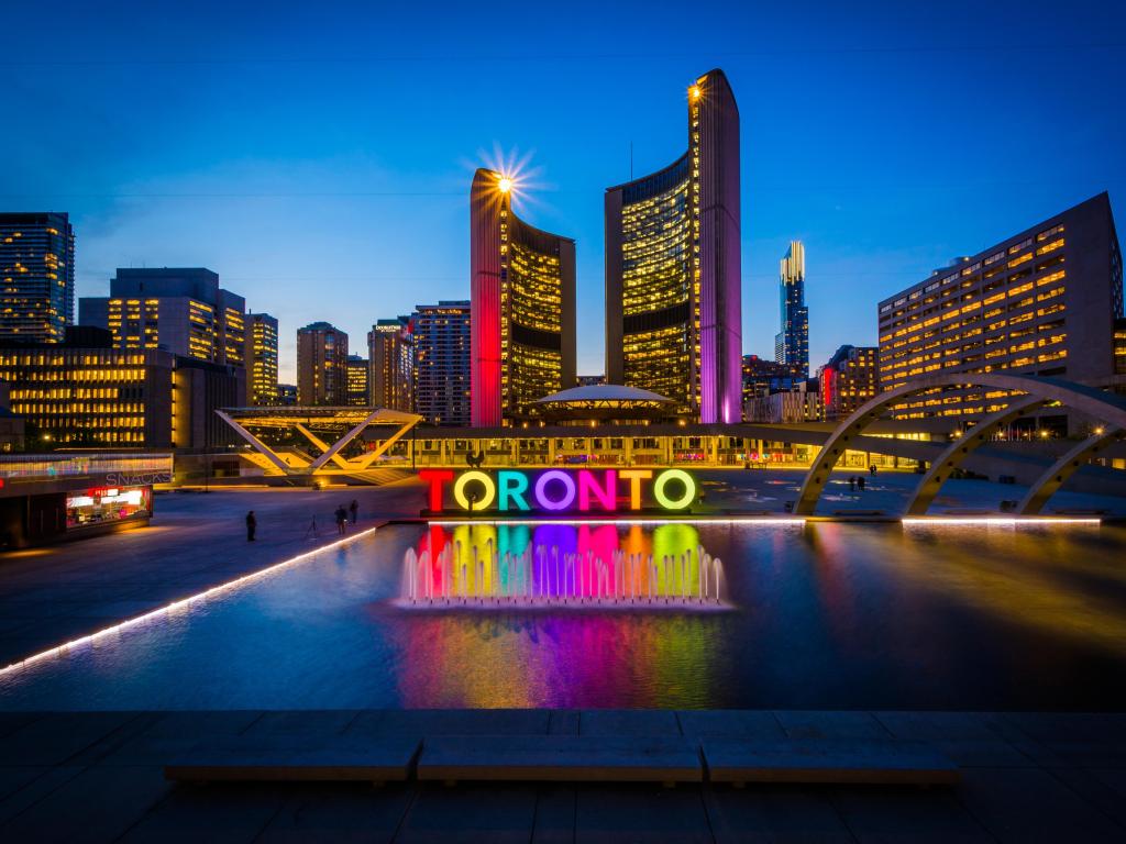 Toronto, Ontario, Canada with a view of Nathan Phillips Square and Toronto Sign in the downtown city at night.