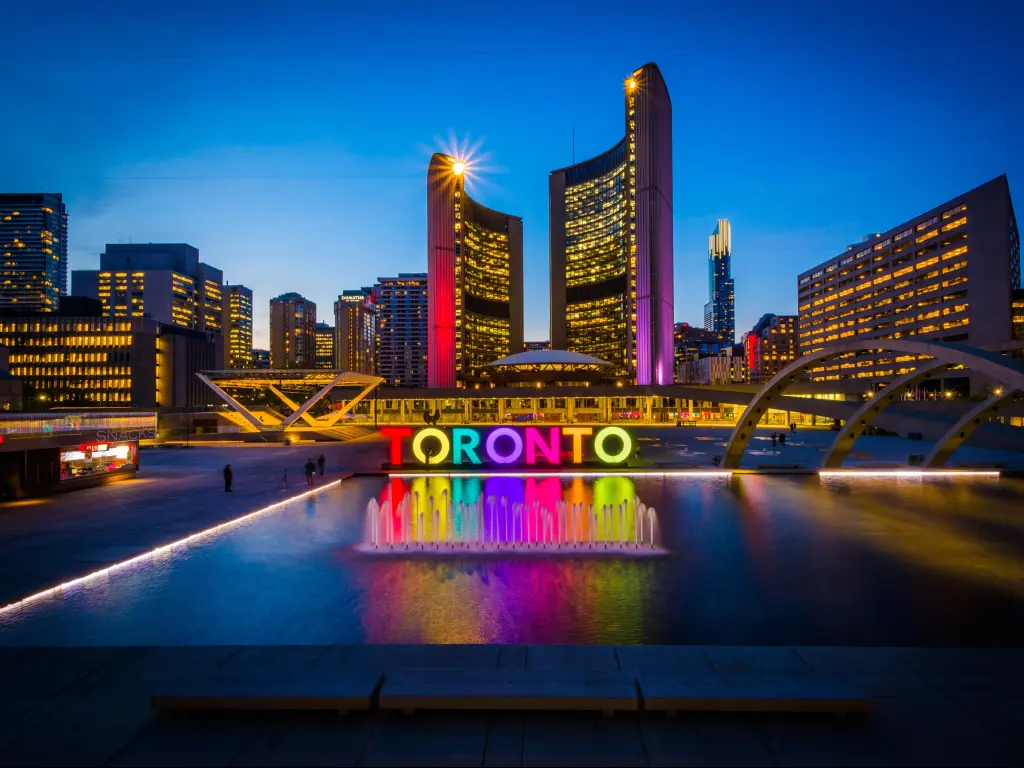 Toronto, Ontario, Canada with a view of Nathan Phillips Square and Toronto Sign in the downtown city at night.