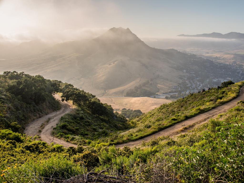 Hiking up Mt Madonna in San Luis Obispo, California, USA on a sunny day with mountains in the distance.