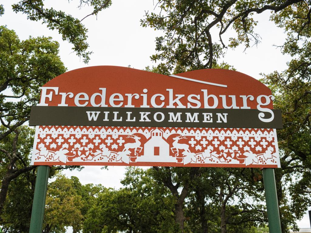 A red and white patterned sign at the German-influenced town of Fredericksburg, Texas reads 