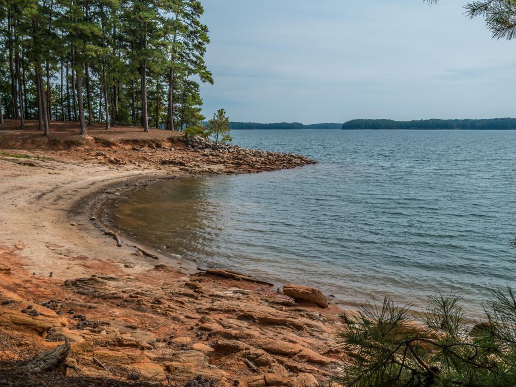 Lake Lanier, Georgia, USA with severe drought conditions at the shoreline exposing the rocks and boulders on a sunny day in fall.