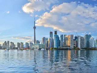 Toronto, Ontario, Canada at sunset with the city skyline in the distance and the vast sea in the foreground. 