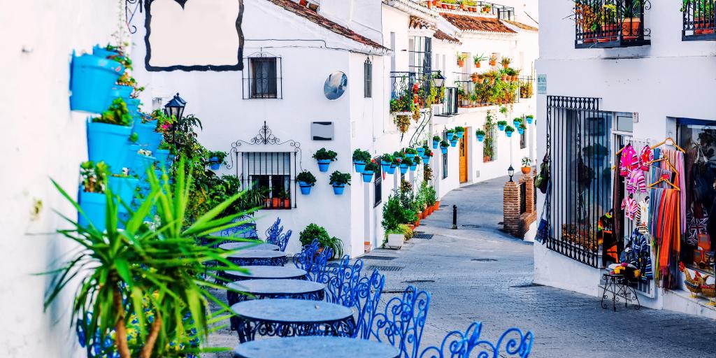 Blue tables and chairs line the charming streets of Mijas