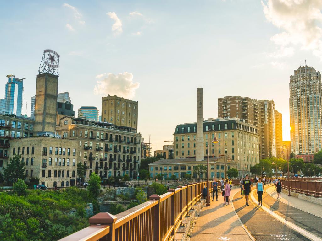 Pedestrians at Mill Ruins Park. View on Stone Arch Bridge at sunset in Minneapolis