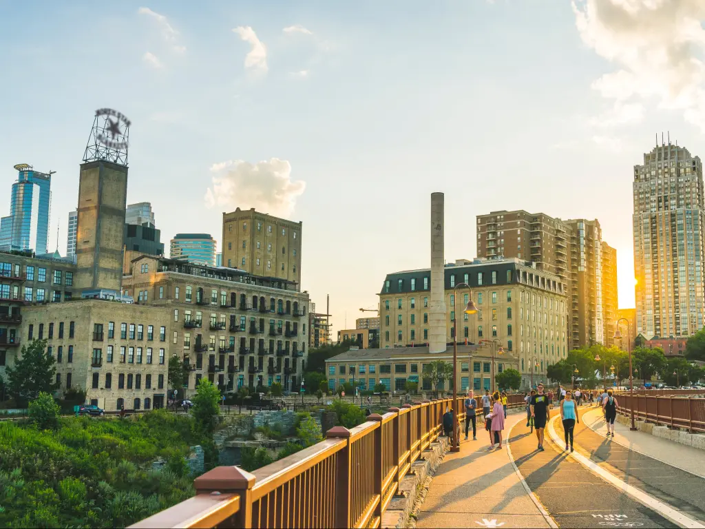Pedestrians at Mill Ruins Park. View on Stone Arch Bridge at sunset in Minneapolis