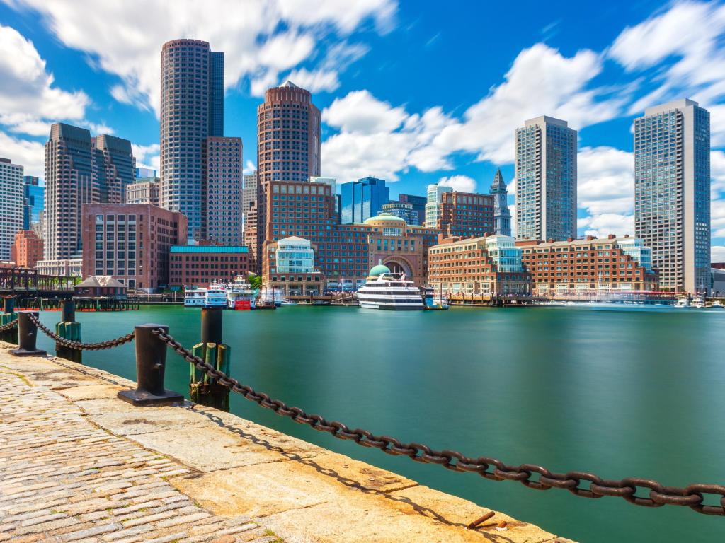 High rise buildings viewed across still blue water of harbor