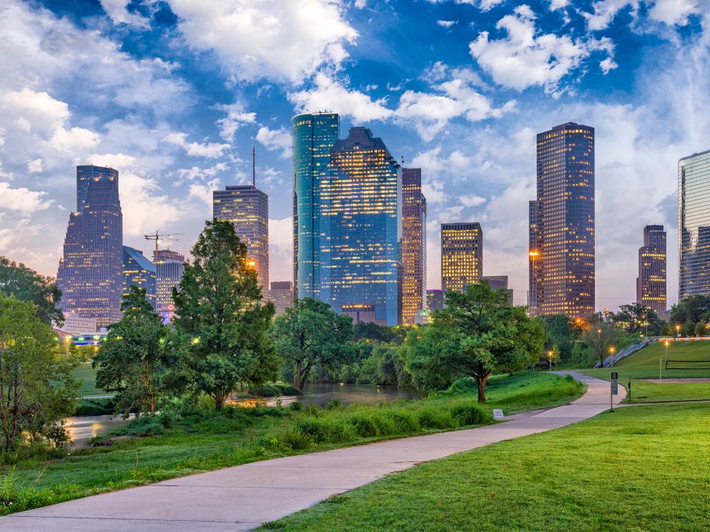 Houston, Texas in the early evening with the city skyline in the background and the a green park in the foreground. 