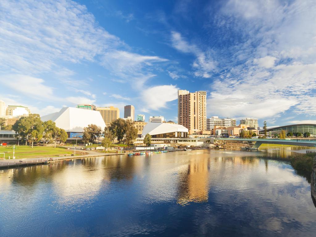 Adelaide, Australia showing the downtown area of the city in the background and the water in the foreground on a sunny day with blue sky.