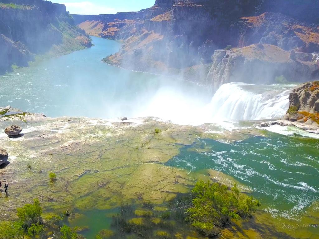 Large waterfall viewed from above, cascading down into a wide river valley