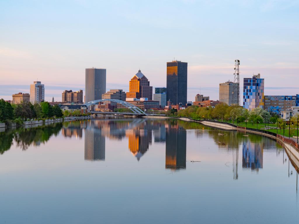 Rochester, New York, USA with the city skyline of Rochester, New York along Genesee River at sunset.